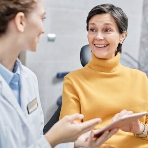 a patient talks to their dentist about dental implants
